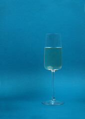 a glass of white wine isolated on blue background