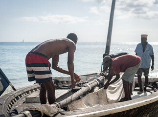 African men working on boat with the sail