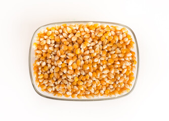 Dry corn in glass bowl on white background.