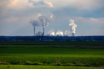A view of the smoking chimneys of a distant coal-fired power plant on the horizon. Photo taken in...