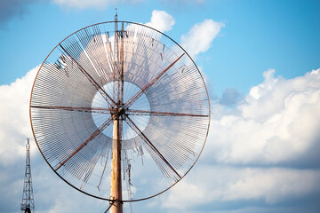 Close-up of the propeller of an old, disused wind farm. Object against the sky with tiny clouds. The photo was taken in natural daylight.
