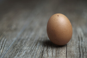 Single brown egg on the wooden table, selective focus