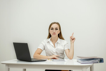 Close-up portrait of a young confident female office manager at her workplace, ready for doing business task.
