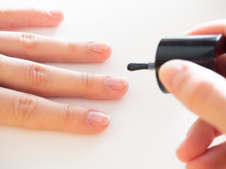 applying a colorless base to the nail. Manicure at home, nail care.
