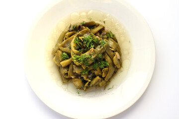 Broad bean and dill in the white plate with white background.