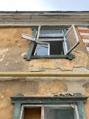 Broken window of an old house. The house is ready for demolition. Second floor, photo from below