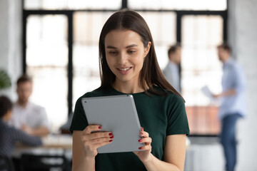 Happy female manager using tablet computer for video call, giving consultation to client. Young...