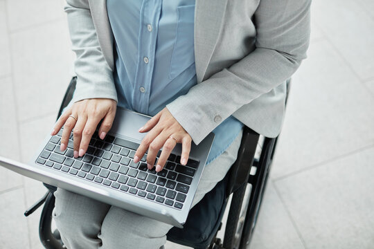 Minimal close up of unrecognizable businesswoman in wheelchair using laptop, copy space