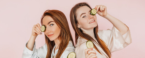 Two girls make homemade face beauty masks. Cucumbers for the freshness of the skin around the eyes....