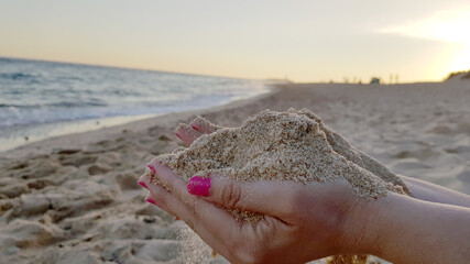 Letting the sand escape between the fingers of the hands