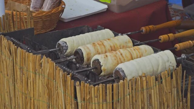 Trdelnik pastry bun, cooked on fire Czech traditional sweet pastry over wrapped around metal stick and baked with cinnamon sugar. European dessert