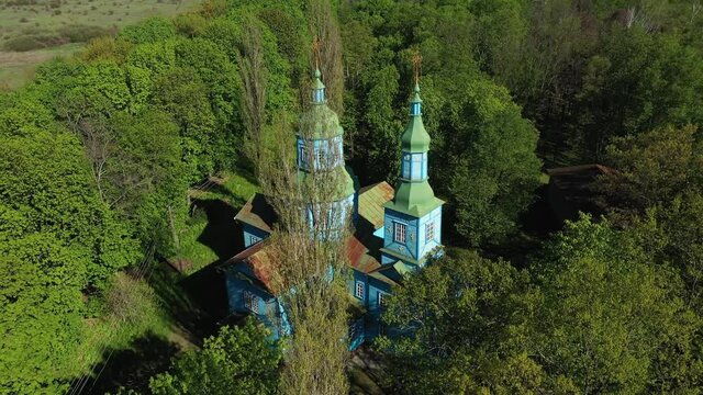 Aerial View of wooden church surrounded by high old trees. Pereyaslav-Khmelnitsky Museum of Folk Architecture and Life of the Middle Naddnipryanshchyna.