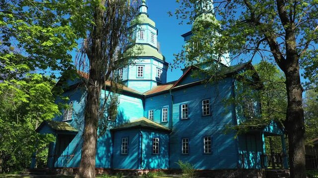 Aerial View of wooden church surrounded by high old trees. Pereyaslav-Khmelnitsky Museum of Folk Architecture and Life of the Middle Naddnipryanshchyna.