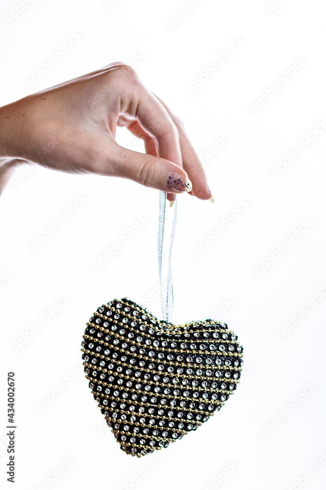 Poster Vertical shot of a female hand holding heart-shaped decoration on an isolated background