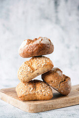 Various buns made from whole grain or plain flour on a wooden board. Traditional bakery products....