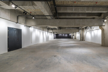 empty interior of large concrete room as warehouse or hangar with spotlights