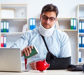 Businessman with broken arm working in office