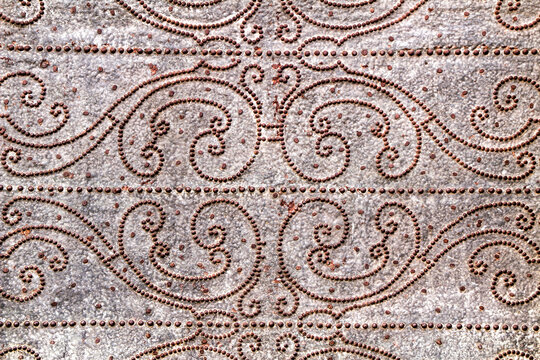 Gray metal door with wrought iron details