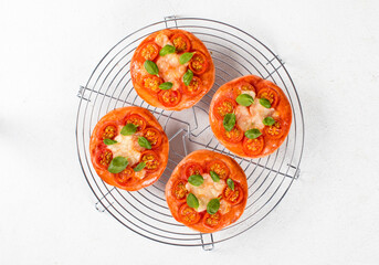 Children mini pizza, small open pies pink with beet juice added to the dough, with cherry tomatoes,...