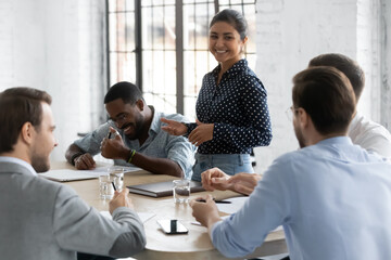 Diverse millennial business team with Indian leader discussing project, brainstorming in office,...