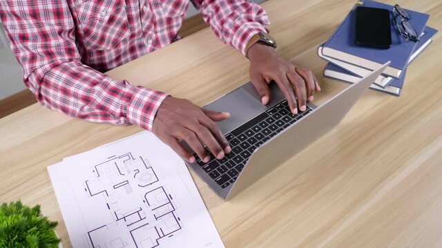Close up hands African Man working with laptop and document on table at home, internet connection, working from home new normal modern lifestyle man siting typing on keyboard, self quarantine covid 19