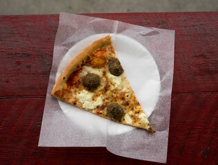 meatball and ricotta pizza on a plate on red table
