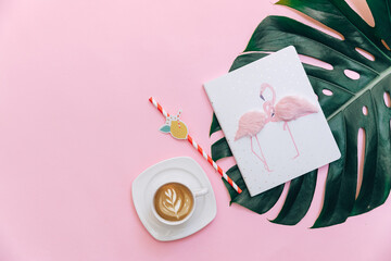 Flat lay workspace with coffee cup and diary on pink background. Minimal blogger concept
