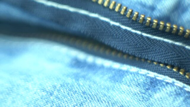 Macro shot of details of a  denim blue jeans pants close up zipper 
