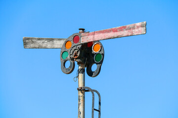antique vintage retro old rusting railroad train tracks light signal with red orange and green lens