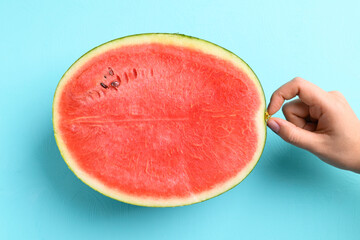 Half watermelon fruit with hand on color background, Tropical fruit, Summer season