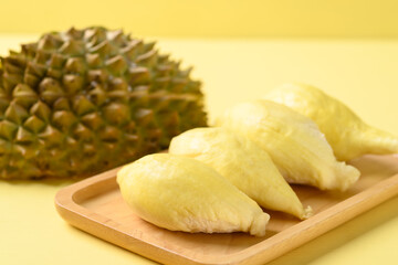 Ripe Thai durian fruit (Monthong) on plate with yellow background, Tropical fruit