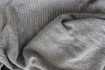 light grey wool sweater with ribbed edges - photographed from above with low or raking light -...