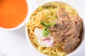 Northern Thai food (Khao soi), Spicy coconut milk curry egg noodles soup with beef in a bowl, Top view