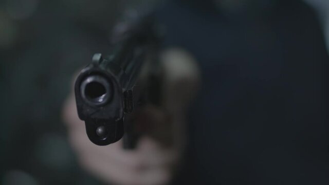 young man raises the gun and pulls the trigger