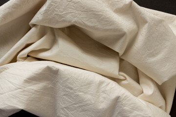 warm ivory yellow cotton blend fabric - photographed from above with low or raking light - emphasis on texture and folds