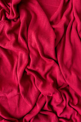 deep red cotton blend button down sweater - photographed from above with low or raking light - emphasis on texture and folds