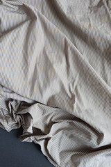 beige and white or light brown sand striped dress shirt with creases and folds - photographed from above with low or raking light - emphasis on texture and folds