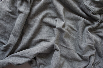 medium grey wool sweater - photographed from above with low or raking light - emphasis on texture and folds
