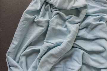 detail of old light blue polo shirt - photographed from above with low or raking light - emphasis...