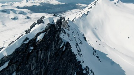 Dangerous flying close to mountain range ridge covered in snow, FPV drone