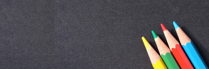 Colored pencils on black background with space for text