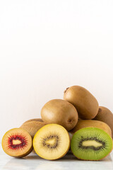 Three Varieties of Kiwi Fruit on a Table, Vertical with Copy Space