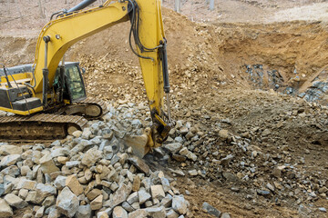 Heavy trucks with moving stone rock in a construction site on load gravel excavator