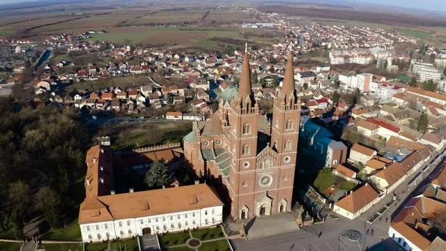 People Walking In The Street In Front Of Dakovo Cathedral, A Catholic Church In Dakovo, Slavonia, Croatia. - aerial
