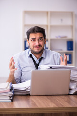 Young businessman employee unhappy with excessive work in the office