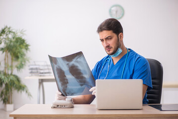 Young male doctor radiologist working in the clinic during pande