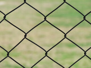 A grid pattern of a fence in a park