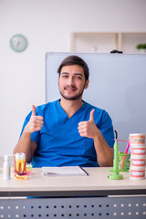 Young male dentist lecturer in front of whiteboard