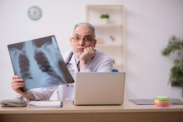 Old male doctor radiologist working in the clinic