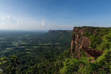 Rescue hiker with backpack climbs natural rocky wall. Wearing in climbing equipment rope carabiner